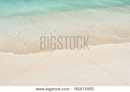 Beautiful marine view on ?aribbean sea coast line with clean wavy surf ocean water on sandy beach in st. john Antigua at sunny day as natural background