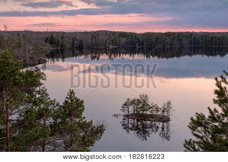Landscape nature image of sunset over forest lake in Tyresta National Park in Stockholm, Sweden.