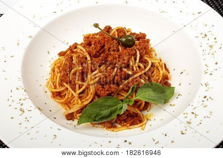 Pasta with meat, tomato sauce, parmesan and vegetables isolated on white background