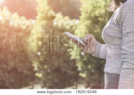Young woman hold her smartphone at sunset