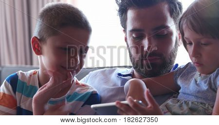 Young Father With Two Kids using technology in modern aprtment