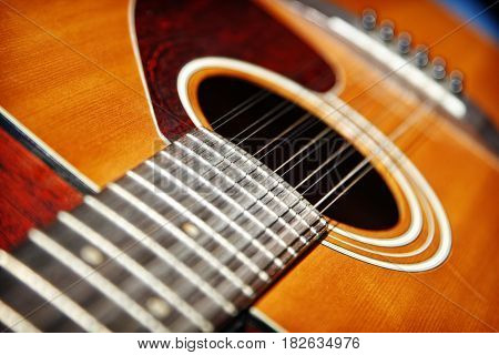 Acoustic Twelve String Guitar.  A close up of the neck and body of an acoustic twelve-string guitar - shallow depth of field.