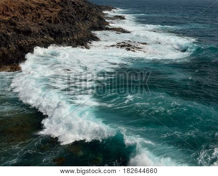 Littoral with groundswell and waves crashing against the rocks