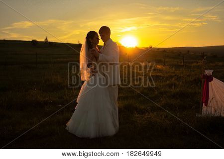 Wedding couple is dansing on the sunset