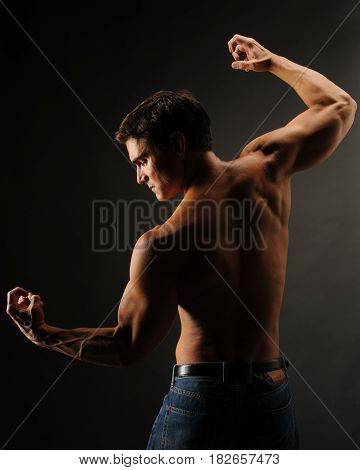 The buff guy is doing a statuesque pose.