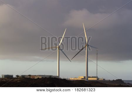 Pair of wind turbines move at sunset beautiful light, Spain, Fuerteventura island