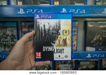 Bratislava, Slovakia, circa april 2017: Man holding Dying Light videogame on Sony Playstation 4 console in store