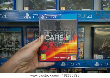 Bratislava, Slovakia, circa april 2017: Man holding Project Cars videogame on Sony Playstation 4 console in store