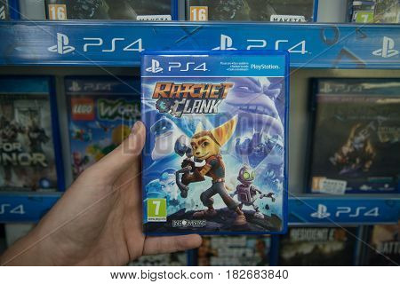 Bratislava, Slovakia, circa april 2017: Man holding Ratchet and Clank videogame on Sony Playstation 4 console in store