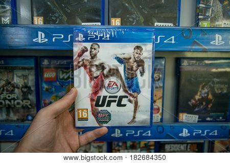 Bratislava, Slovakia, circa april 2017: Man holding UFC videogame on Sony Playstation 4 console in store