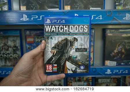 Bratislava, Slovakia, circa april 2017: Man holding Watch dogs videogame on Sony Playstation 4 console in store