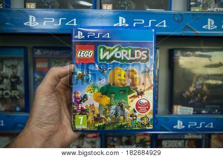 Bratislava, Slovakia, circa april 2017: Man holding Lego Worlds videogame on Sony Playstation 4 console in store