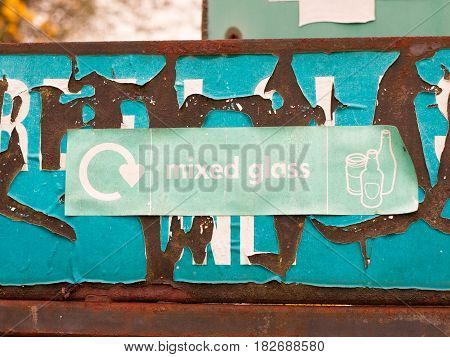 A Green Recycling Sign Near Glass Recycle Plant And Bins Saying Mixed Glass With Pictures Of Jars An