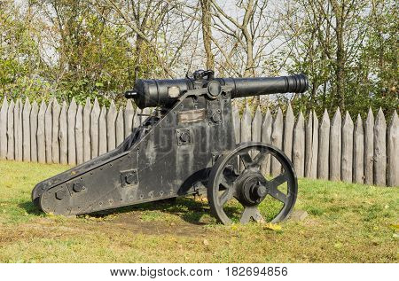 Old cannon on the grass cast iron close-up