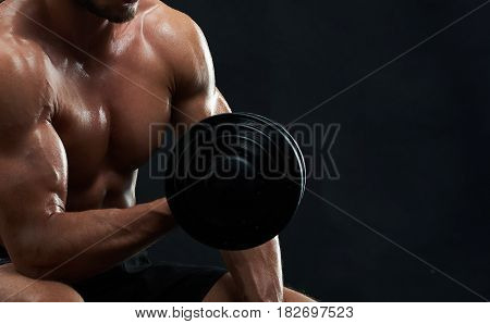 Cropped close up shot of a muscular man with strong sexy hot ripped body working out with dumbbell on black background copyspace gym fitness sportsman sportive bodybuilding nutrition diet concept.