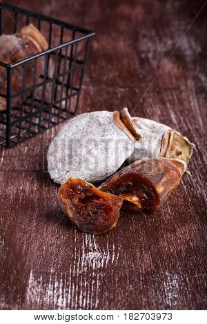 Dried persimmon fruits on dark brown background