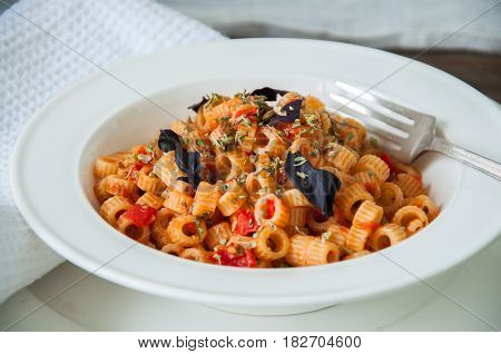 Close Up Of Tomato Sause Pasta And Basil In A White Plate.