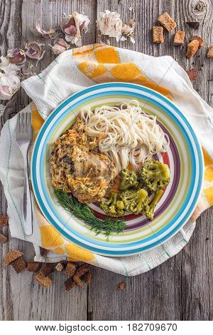 Pasta with chicken and vegetables on a dark wood in a rustic style