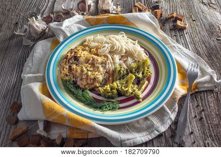 Pasta with chicken and vegetables on a dark wood in a rustic style