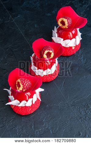 Romantic French Choux Pastry With Raspberry Mousse Cream Covered With Red Mirror Glaze And Rose Peta
