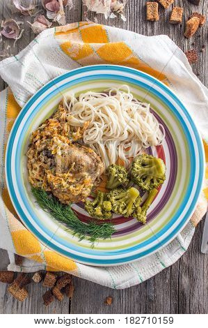 Pasta with chicken and vegetables on a dark wood in a rustic style