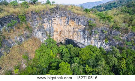 aerial photography above amazing cave. Tham Than Lod Yai is the big cave and have one hole on the top of the cave. it is a short cave there have waterfall pass inside through to another cave