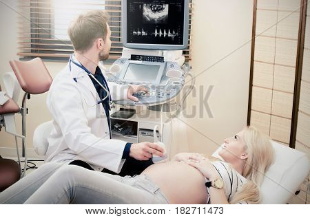 Pregnant Woman At The Doctor. Ultrasound Diagnostic Machine.