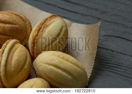 Cookies with boiled condenced milk on cooking paper, close-up
