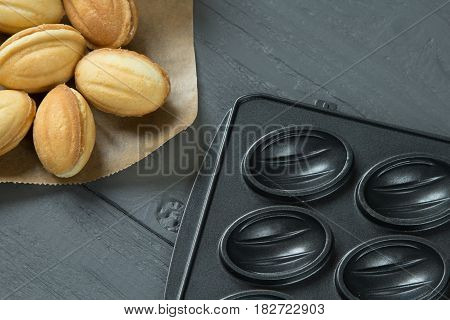 Cookies with condenced milk and baking-mold on wooden background