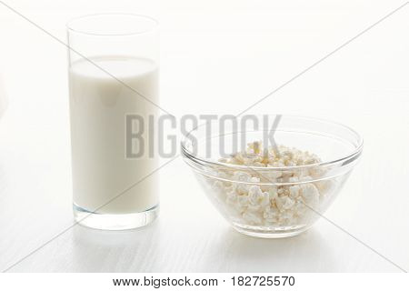 Milk In A Glass, Cottage Cheese In A Bowl, On A White Table, In A High Key, Close-up With Place For