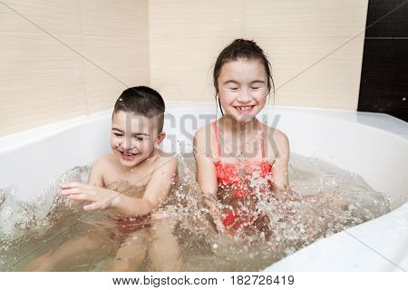 Happy brother and sister playing in the bathroom. Cpncept of child's hygiene, healthy lifestyle, carefree childhood