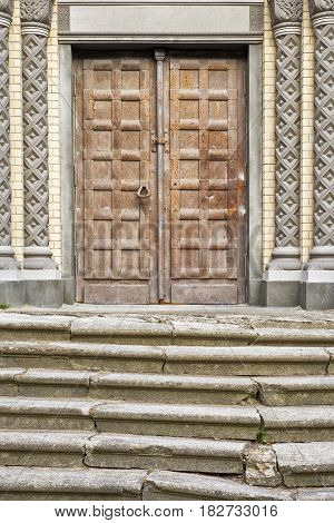 old cracked stairs and brown grunge rusty metal door of the church