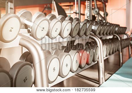 Rows of dumbbells in the gym with hign contrast and monochrome color tone