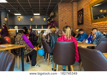 Eskisehir Turkey - April 15 2017: People enjoy eat and drinks in the opening of Krepya Cafe. People sitting at a cafe table.