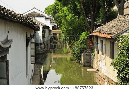 Weathered Chinese buildings line the water canals of Luzhi water town in Jiangsu province china.