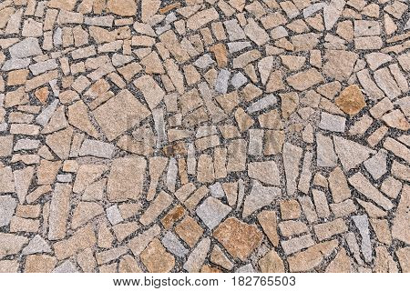 Paving blocks made of asymmetrical stone. The stone pavement as the background texture Stone block road pavement