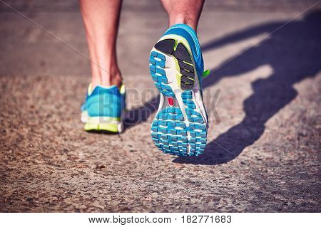 Running athlete during training outdoors in the summer on a sunny day.