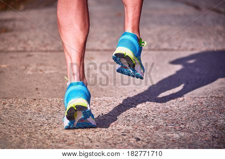 Running athlete during training outdoors in the summer on a sunny day.