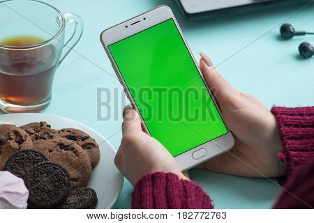 Beautiful girl holding a smartphone in the hands of a green screen green screen, hand of man holding mobile smart phone with chroma key green screen on white background