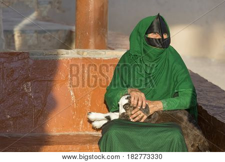 Omani Woman In A Market With A Baby Goat