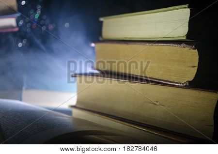 Many Old Books In A Stack. Knoledge Concept. Books On A Dark Background With Smoke Elements. Bewitch