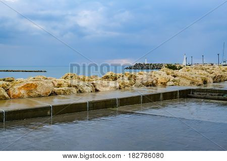 Zygi fishing village harbour entrance from the shore after a shower in spring.