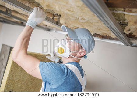Wool Home Insulating. Caucasian Home Renovation Worker with Mineral Wool.