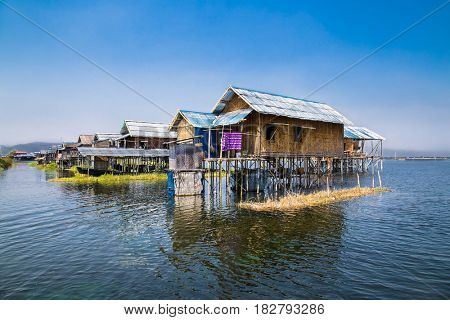 Ancient houses and their reflection in the water on the Inle Lake, Myanmar. (Burma)