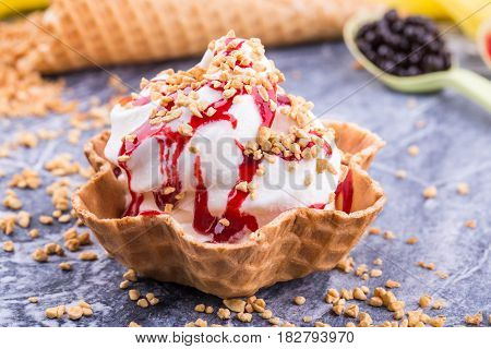 Raspberry ice cream in a basket with shredded nuts