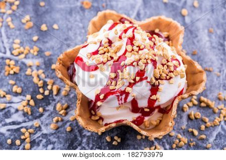 Ice cream with raspberry jam, is served with shredded nut
