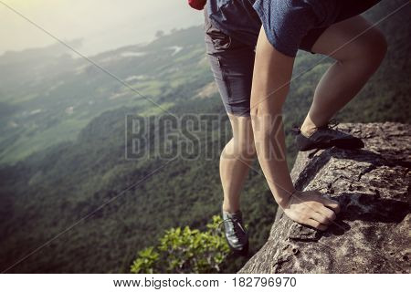 success young woman rock climber on mountain peak