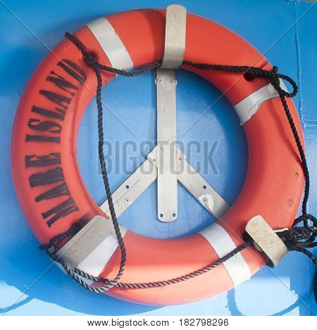 Bright orange life ring forming peach sign against blue background of ferry boat with words: Mare Island