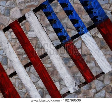 Painted pallet of American flag against a rock wall