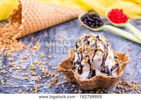 An ice cream basket with chocolate jam, sprinkled shredded nuts